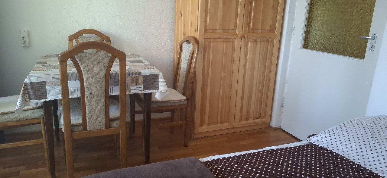 Étkezőasztal székekkel és szekrénnyel a földszinti lakásban