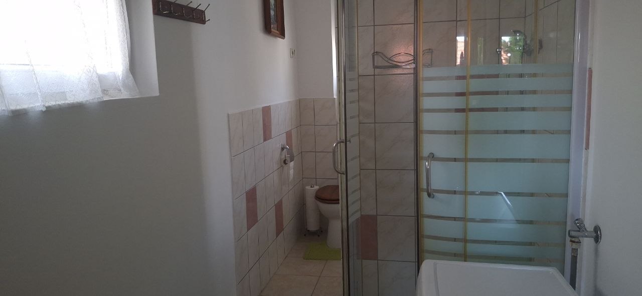 Földszinti fürdőszoba zuhanykabinnal, WC-vel és mosógéppel