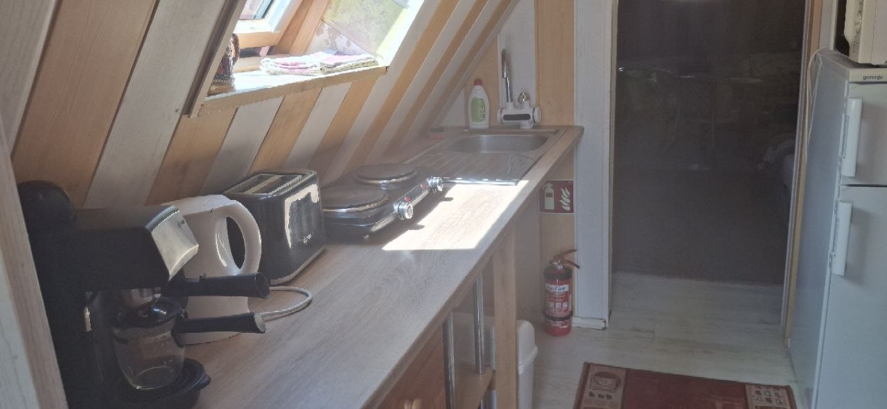 Konyhasarok mosogatóval, rezsóval, vízforralóval, kenyérpirítóval és kávéfőzővel
