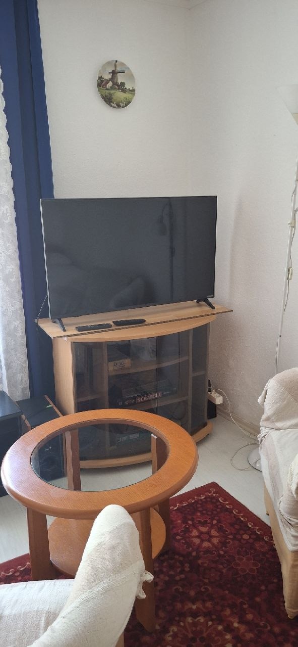 TV-sarok lapos képernyővel, szekrénnyel és dohányzóasztallal a földszinten