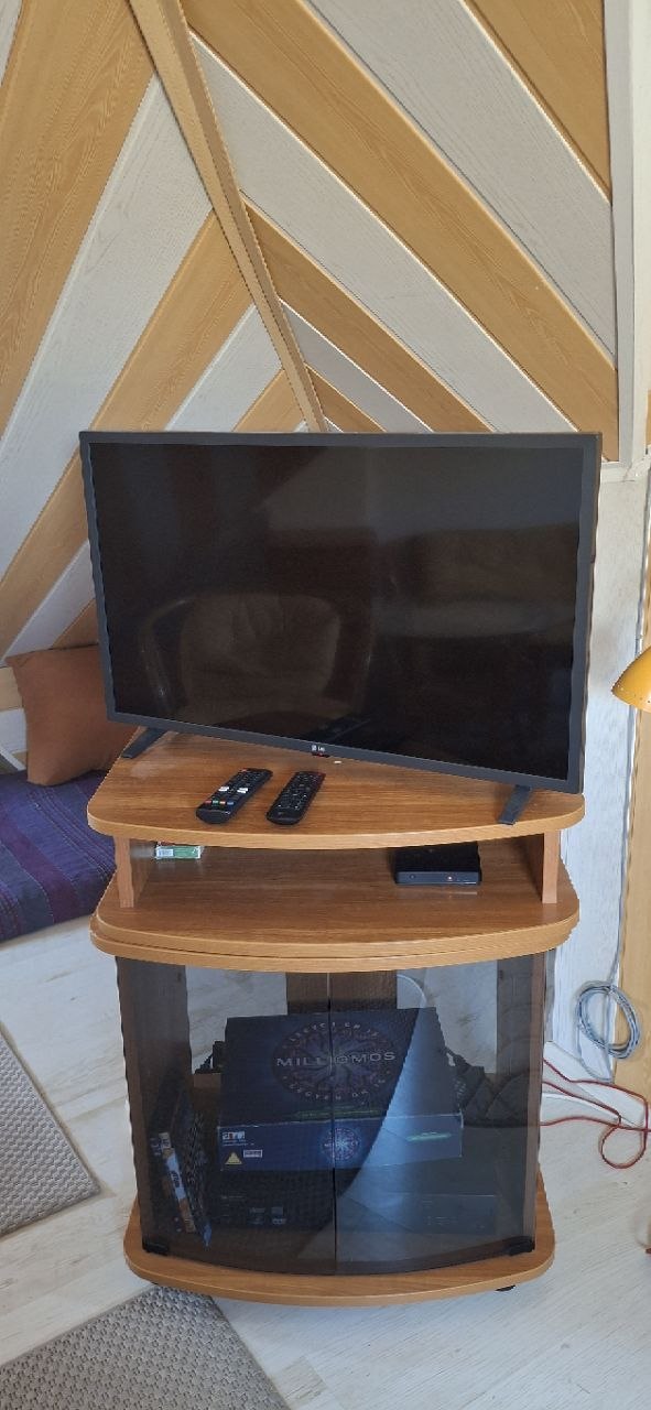 Lapos képernyős TV szekrényen a faburkolatú tetőtérben